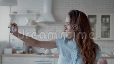漂亮的女人在厨房自<strong>拍照</strong>片。 女人摆<strong>姿势拍照</strong>。